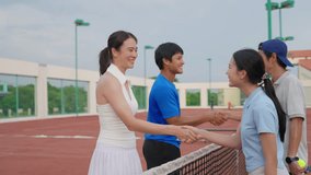 Group of Asian friends playing tennis match on an outdoor clay court. Attractive man and woman athletes making handshake, enjoying competitive match game and energetic workout on sports field together - Powered by Shutterstock - Get 15% off with code: PIKWIZARD15