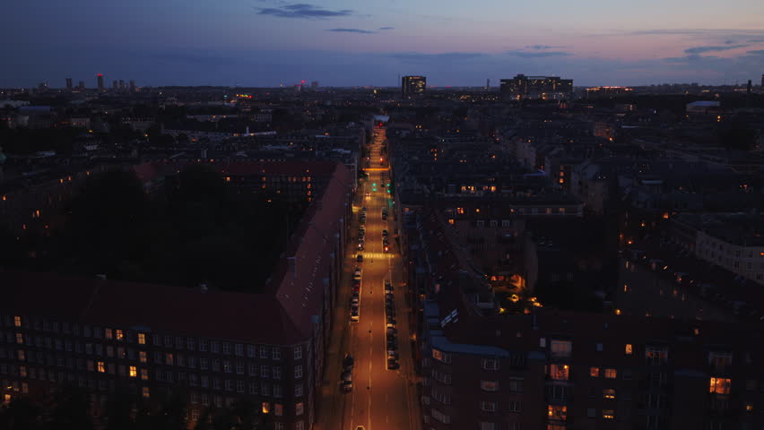 Aerial drone view of a straight city street lit up at night in Osterbro district, Copenhagen, Denmark