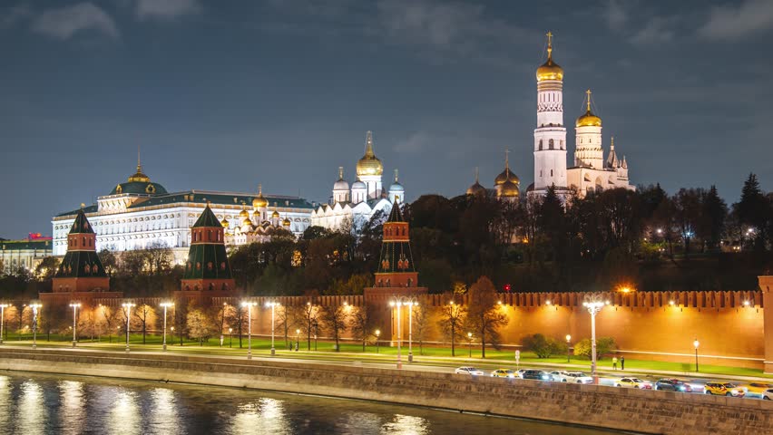 The Kremlin Embankment and the Moskva River, with fast-moving clouds in the night sky