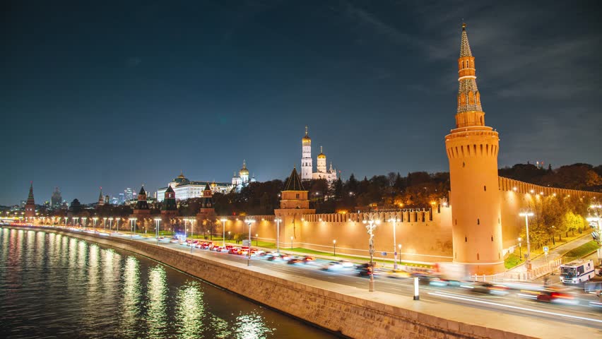 The Kremlin Embankment and the Moskva River, with fast-moving clouds in the night sky