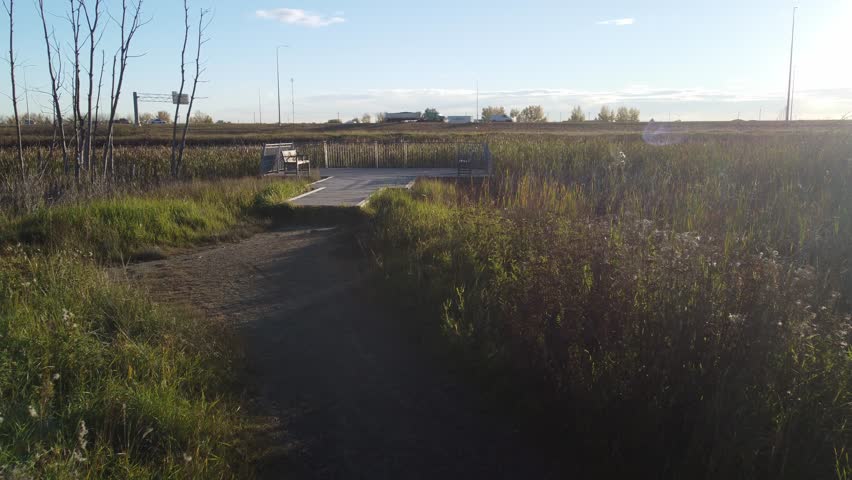 Empty benches by pond and highway on deck close up
