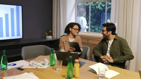 Smiling diverse coworkers discussing project and sharing ideas with digital tablet in modern office showing teamwork communication and creativity in positive corporate environment - Powered by Shutterstock - Get 15% off with code: PIKWIZARD15