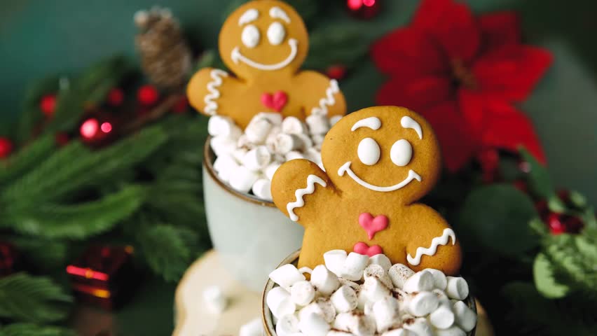 Gingerbread man cookies in cups with marshmallows and festive holiday decorations