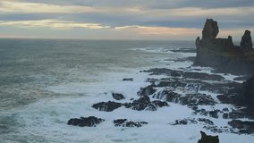 A wide angle shot of the rugged coastline of the Snæfellsnes Peninsula in Iceland, featuring the iconic Lóndrangar basalt sea stacks. Waves from the Atlantic Ocean crash against the black lava rocks a - Powered by Shutterstock - Get 15% off with code: PIKWIZARD15