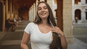 Young woman reaches arms forward with bare hands in building corridor smiling to camera; joyful welcome. - Powered by Shutterstock - Get 15% off with code: PIKWIZARD15