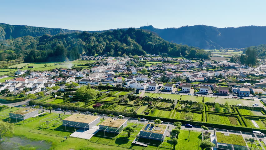 Aerial view of Sete Cidades village surrounded by green hills inside volcanic caldera, Sao Miguel Island, Azores