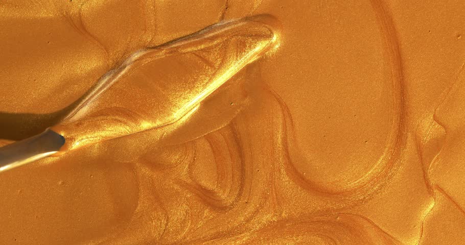 Golden brushstroke of liquid gold paint texture background, mixing with spatula. Liquid gold art design background.