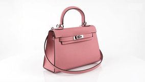 Seamless 4K 360° rotation of a stylish warm pink leather handbag with a shoulder strap, elegant design, silver clasp, and fine stitching on white background. Perfect for fashion ads. - Powered by Shutterstock - Get 15% off with code: PIKWIZARD15