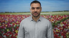 Man holds up hand in ok sign among vibrant tulip flowers in forest under bright blue summer sky; optimism. - Powered by Shutterstock - Get 15% off with code: PIKWIZARD15