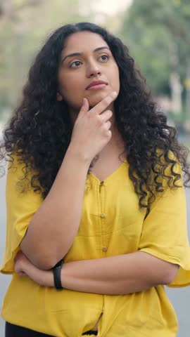 Vertical Video of Indian Girl with Curly Hair Getting an Idea