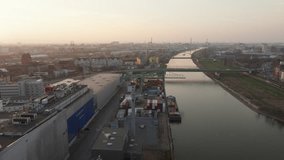 Aerial view of Mannheim's industrial harbor with a container terminal and cargo ship on river canal at sunset. Large warehouse and cityscape - Powered by Shutterstock - Get 15% off with code: PIKWIZARD15