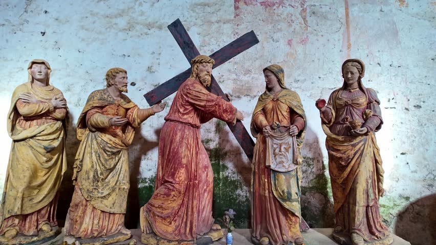 Antique wooden statues depicting Jesus Christ carrying the cross, meeting Saint Veronica, Stations of Cross scene for religious or historical content. Close-up