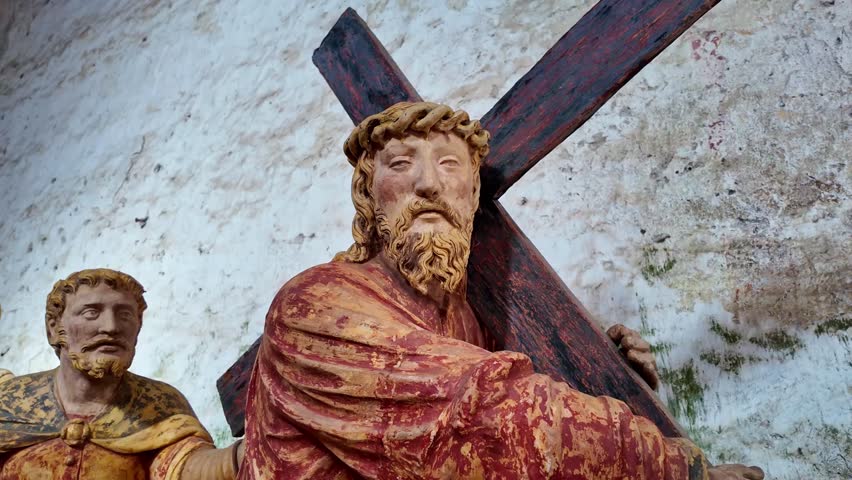 Close-up of antique wooden statue of Jesus Christ carrying the cross, wearing crown of thorns