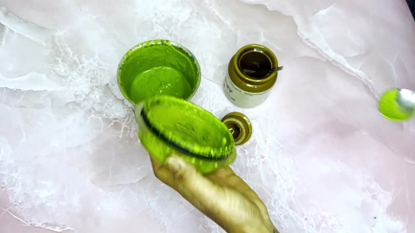 Hands blend leafy chutney paste inside Indian kitchen, Lady Holds Spoon Displaying Thick and Tasty Green Mix, Homemade Herb Prepared in Hygienic Space, Self Made Leaf Mixture Creates Savory Delight