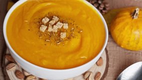 Warm pumpkin soup with croutons, autumn leaves, pumpkins, apples, and a flickering candle creating a festive seasonal mood - Powered by Shutterstock - Get 15% off with code: PIKWIZARD15