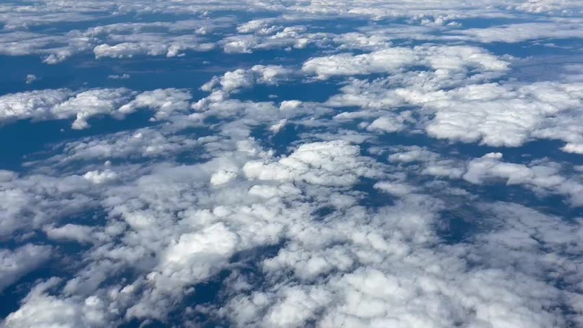 Majestic and beautiful aerial timelapse of a sea of white clouds over the blue ocean and green earth, capturing the grand and spectacular beauty of nature from a high altitude.