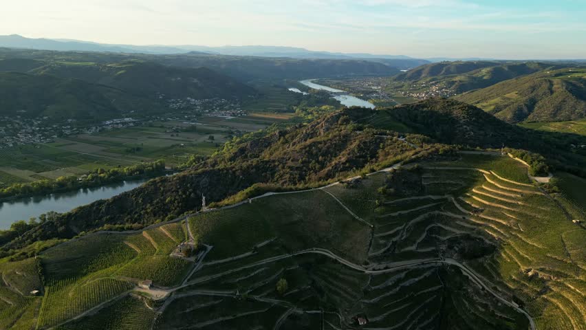 An aerial footage of the steep vineyard hills of Tain Hermitage overlooking the Rhone River in the Rhone Valley, France at sunset