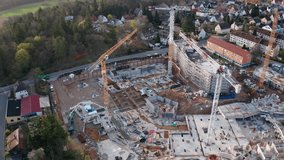 Detailed aerial view of a multi-building residential construction site in Stein, near Nuremberg, Germany. Heavy machinery, cranes, and modular foundations highlight the role of housing and the EU econ - Powered by Shutterstock - Get 15% off with code: PIKWIZARD15