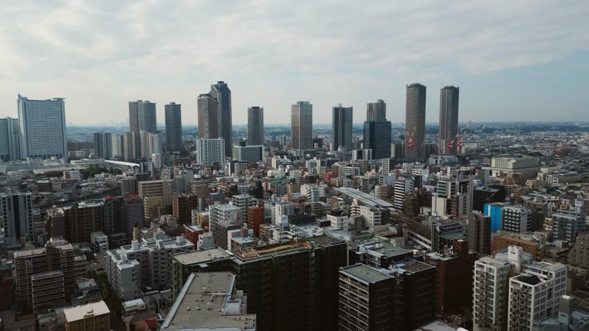 Drone pulls back over Musashi Kosugi showing skyline of Japan trade integration