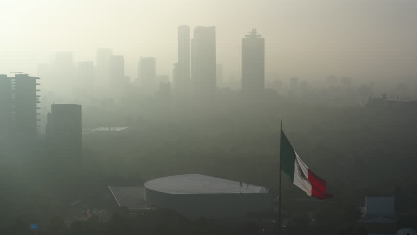 Aerial view of Mexico City’s skyline at sunrise blanketed by thick smog and pollution, highlighting the challenges of urban air quality in one of the world’s largest megacities.