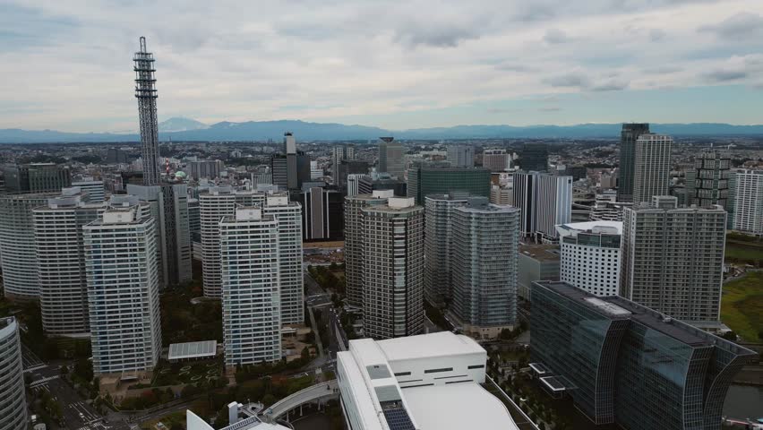 Slow backward drone flight over Yokohama Minato Mirai and Mount Fuji