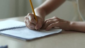 Close up hand of kid girl writing, school child doing homework sitting at table. Student studying indoors. Education concept. Selective focus - Powered by Shutterstock - Get 15% off with code: PIKWIZARD15