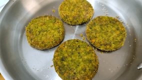 Cooking four vegan burger patties in a stainless steel frying pan - Powered by Shutterstock - Get 15% off with code: PIKWIZARD15