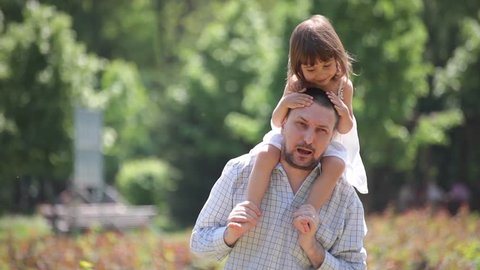 Father holds daughter on shoulders, piggybacks and plays with her.
 – Stockvideo