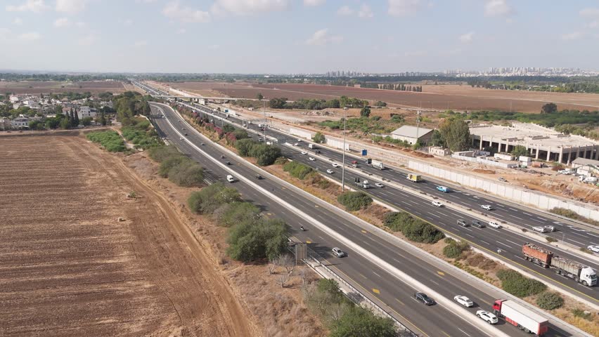 Aerial view of Highway road 6 with sparse traffic flowing through the landscape, Rosh HaAyin, North District, Israel.