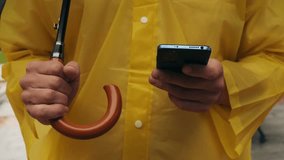 Using phone taxi app during rain, Unrecognizable man standing on the city streets under umbrella and using cellphone - Powered by Shutterstock - Get 15% off with code: PIKWIZARD15
