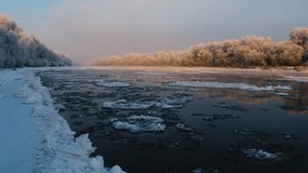 wide angle view of a partially frozen river at dawn in the South Urals region of Russia. The soft, golden light of the rising sun illuminates the frosty trees and snow covered banks, creating a tranqu - Powered by Shutterstock - Get 15% off with code: PIKWIZARD15