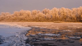 A beautiful winter landscape at sunrise in the South Urals region of Russia. The footage captures a partially frozen river with floating ice floes, bordered by a forest of trees covered in hoarfrost a - Powered by Shutterstock - Get 15% off with code: PIKWIZARD15