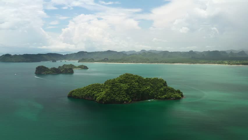 Tropical islands overgrown with jungle on the island of Langkawi, surrounded by clear blue waters. Malaysia