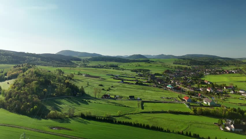 Charming Polish Village in Mountain Region with Country Road, Green Fields, and Blue Sky