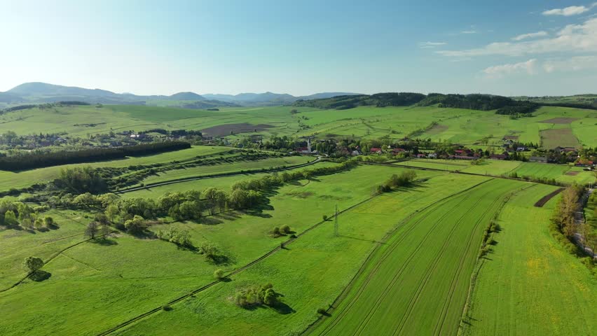Charming Polish Village in Mountain Region with Country Road, Green Fields, and Blue Sky