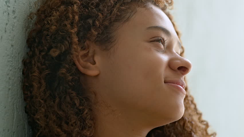 Side Profile Of Teenage Girl With Curly Hair Smiling Gently While Leaning Against Wall, Peaceful Moment With Soft Light And Thoughtful Expression