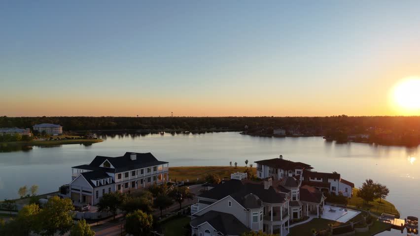 Aerial view of luxurious Woodlands houses neighborhood by the lake in Houston, Texas, USA at sunset time