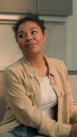 African American woman unpacking cardboard box with cloth shopping online delivery buying textile happy girl homeowner female on couch enjoying moving day in new home preparing for living in apartment