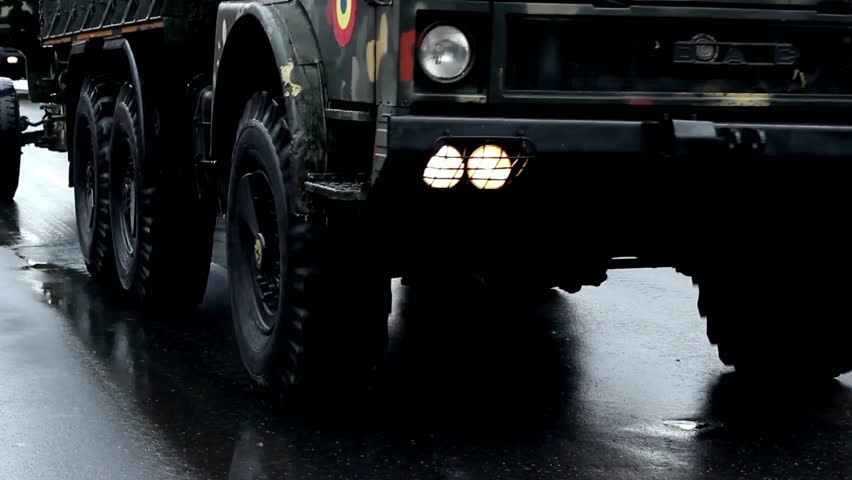 Close-up of rubber tires of a moving armored personnel carrier at a military parade.