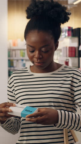 African American woman happy customer buying pills in pharmacy drugstore ethnic female shopper drugs vitamins antibiotic medicine health care shopping beauty supplements treatment symptoms smiling