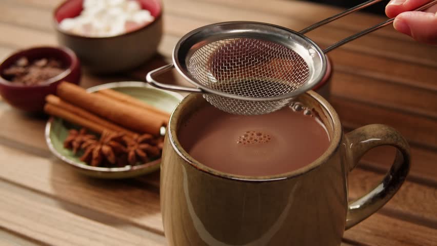 Making cocoa cacao hot chocolate with marshmallows. Man takes a spoon and mixing milk with cocoa powder. 