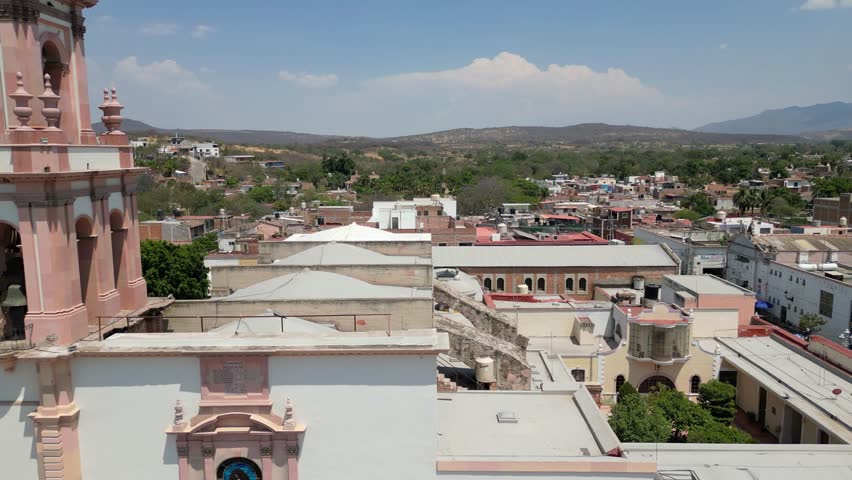 Aerial backward motion from the main church in Cocula unveiling the full view of the town plaza
