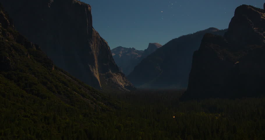 A tranquil night timelapse of Yosemite’s Tunnel View under the moonlight. El Capitan and Half Dome rise over the valley as stars shimmer in the clear California sky.