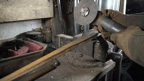 A skilled worker uses a handheld grinder to sharpen a metal bar in a busy workshop. The sun shines through the windows, lighting up the tools and equipment around. - Powered by Shutterstock - Get 15% off with code: PIKWIZARD15