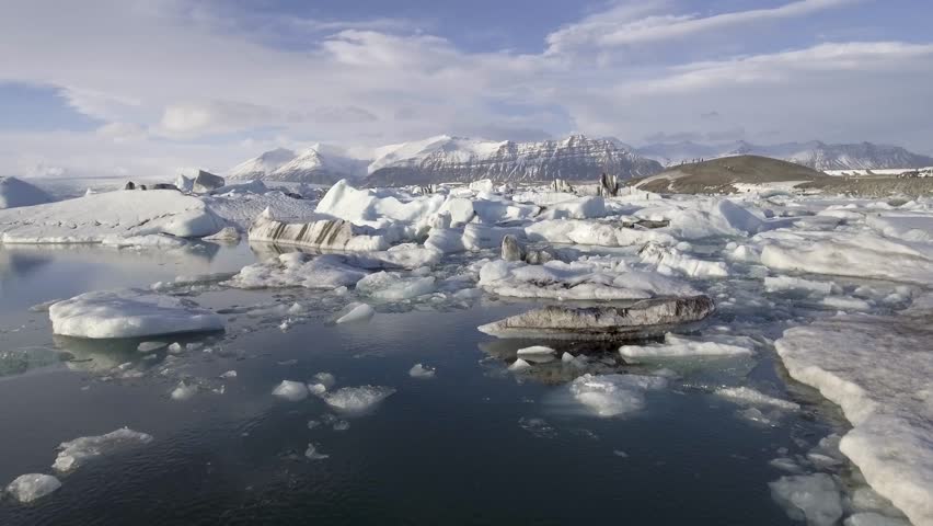 Aerial view of Jokulsarlon glacier lagoon with iceberg floating and mountains on background - Beautiful drone view of Vatnajokull area, nature and travel concepts