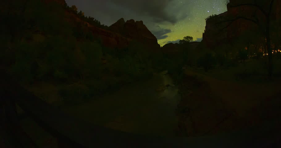 A dramatic night timelapse showing storm clouds passing through a star trail sky above the cliffs of Zion National Park, Utah and over the Virgin River. Thunderstorms and Clouds roll in at the end. 
