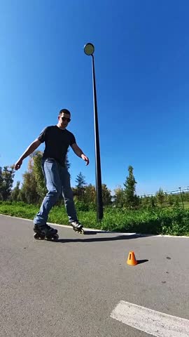 A Caucasian man rollerblades around the slalom course.