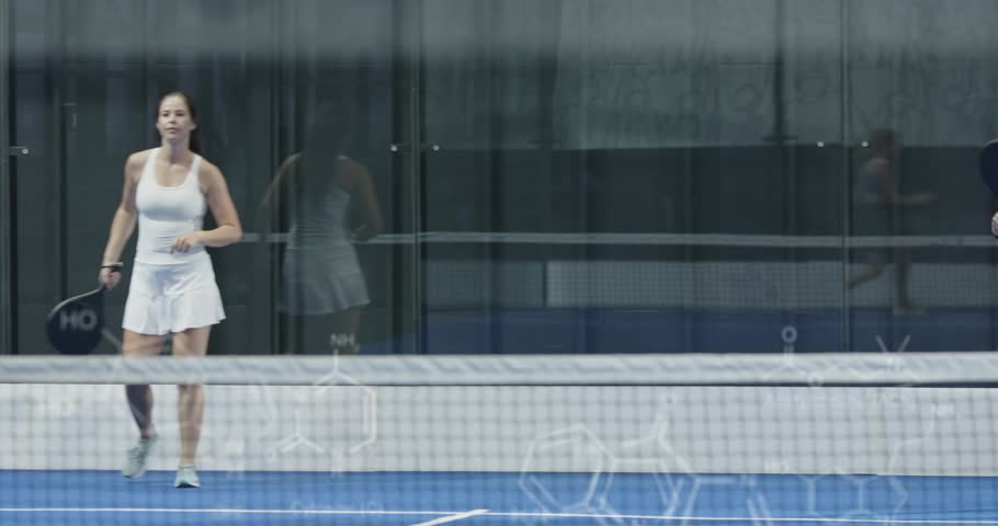 Athlete stepping onto blue court for sports training sharing high fives before male player joining. Athletics, teamwork, camaraderie, sportsperson, training, vibrant, activewear