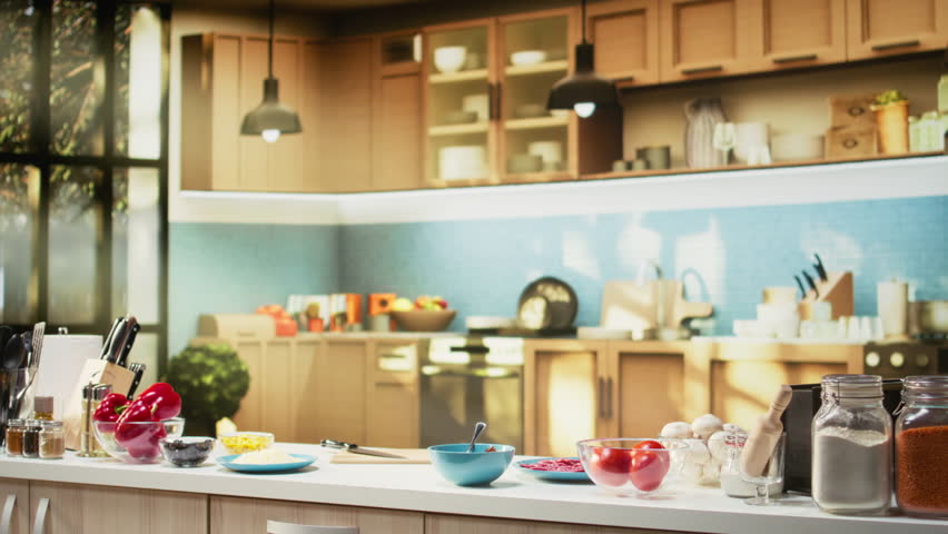 Comfortable kitchen setup with pizza ingredients on a modern countertop. Bowls of cheese, tomatoes and pepperoni sit beside spices and kitchenware, ready for a fun weekend activity of cooking.