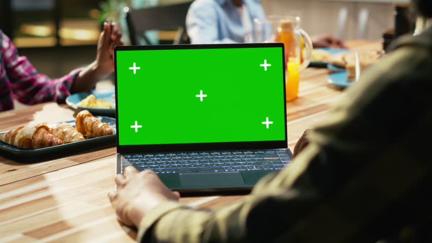 Mockup screen with African American family gathered for breakfast in the kitchen. Parents serve milk and orange juice while children enjoy granola and fruit, homemade meal at home. Camera B.